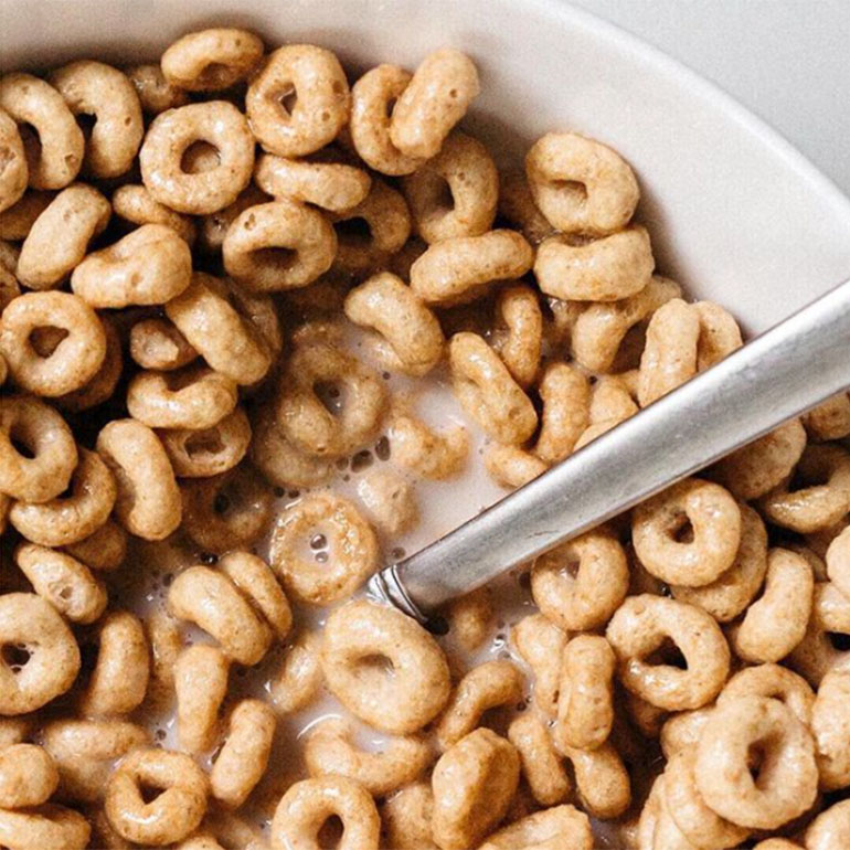 A bowl of cheerios with a spoon in it